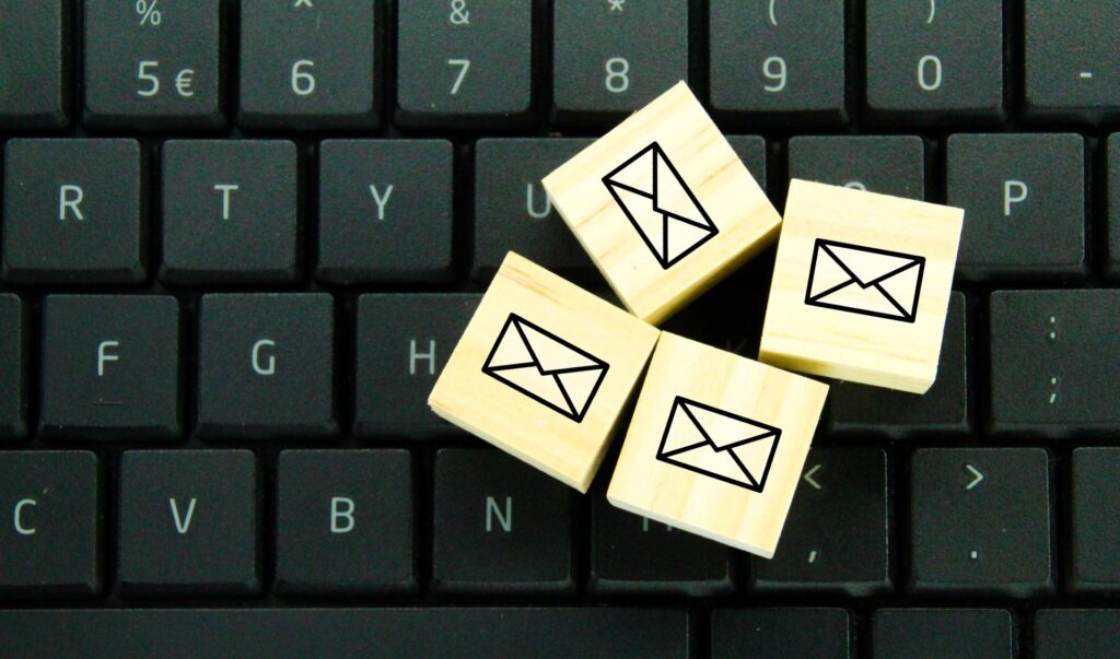 Icône d'email sur un cube en bois symbolisant la gestion d'emails via Webmail44