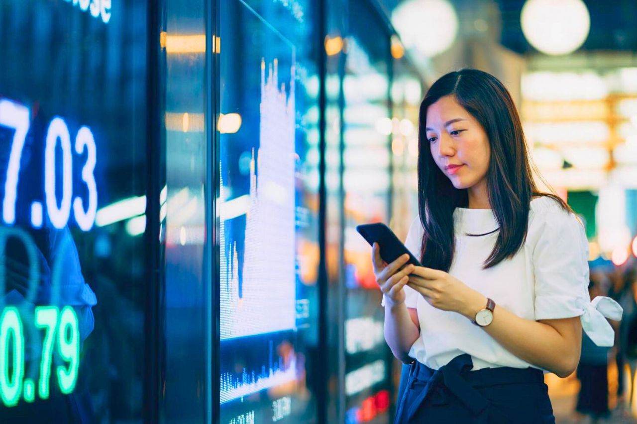 Femme pointe son salaire sur smartphone en Thaïlande