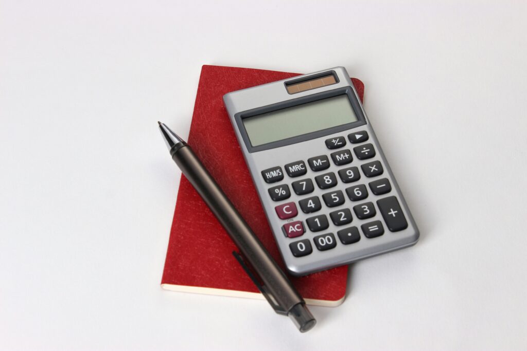 Calculatrice noire et argentée à côté d'un stylo noir